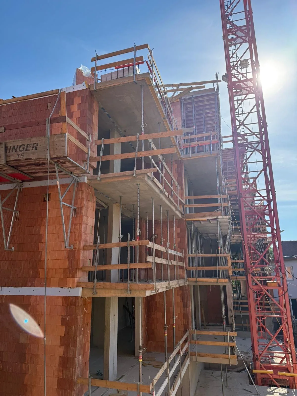Rohbau mit Ziegelmauerwerk, Gerüst und Baukran